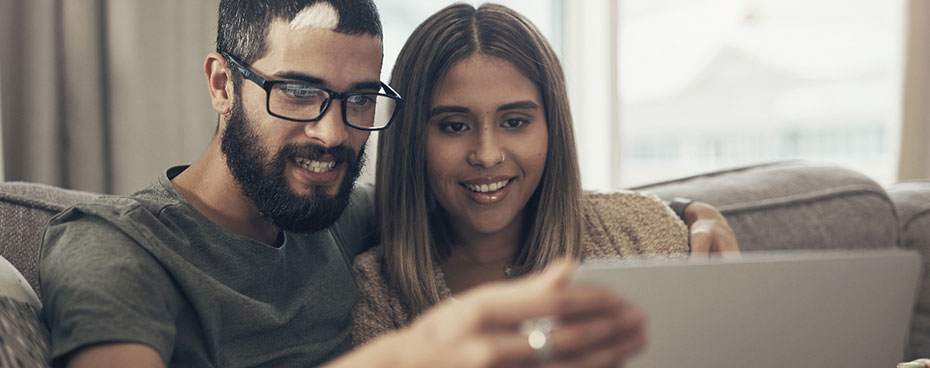 Lachend stel kijkt samen naar laptop